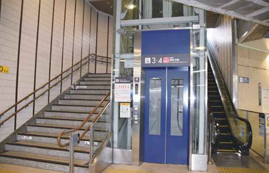 公共施設の中に階段、エレベーター、エスカレーターが隣り合わせに並んでいる写真