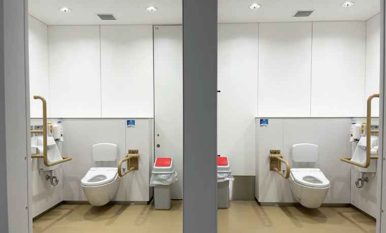 便器へのアクセスを左右どちらからでも選択できるよう、左右対称に設備が設置された個室の写真